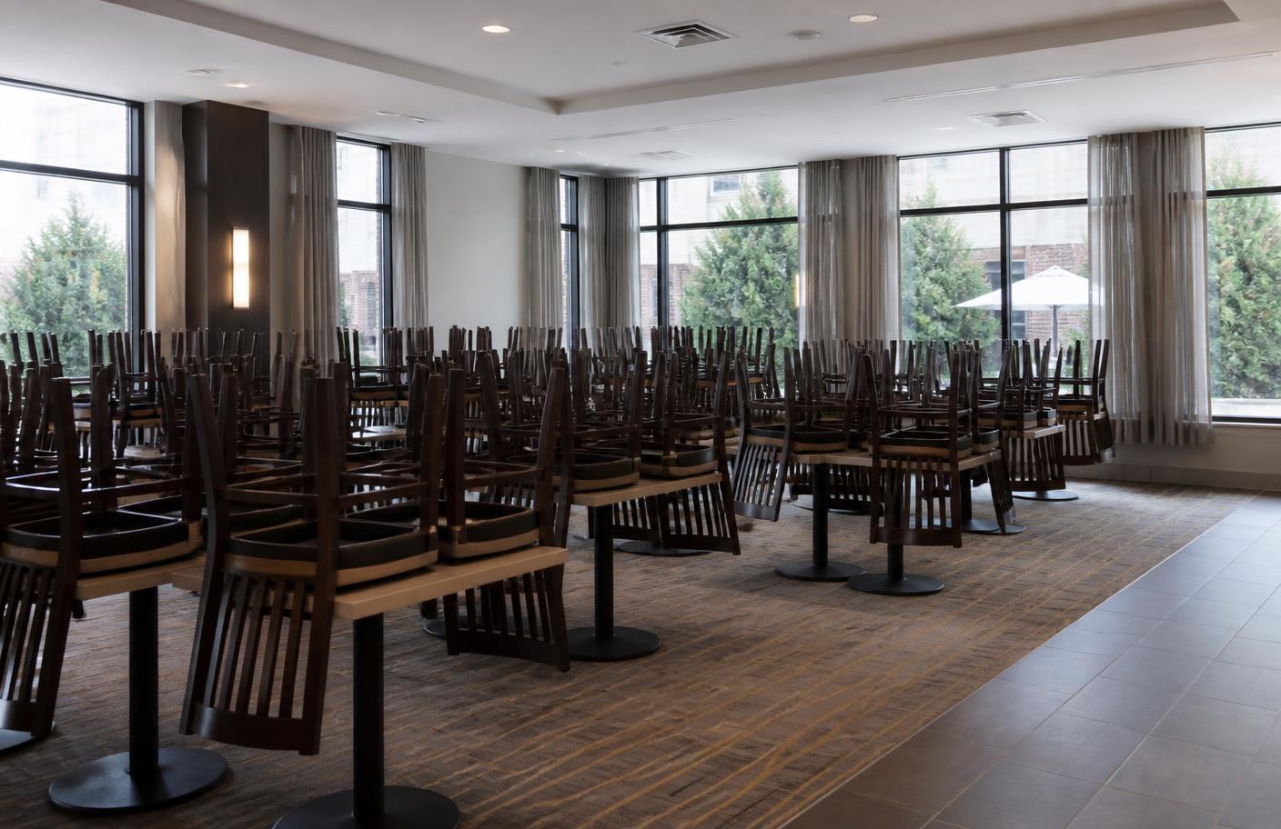 Leerer Restaurantsaal mit aufgestuhlten Tischen