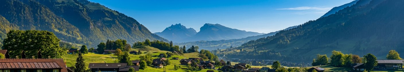 Blick über Frutigen im Kandertal mit grünen Hängen und Bergkette