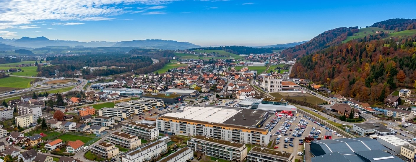 Luftaufnahme von Heimberg mit Wohnquartieren, Gewerbegebiet und bewaldeten Hängen